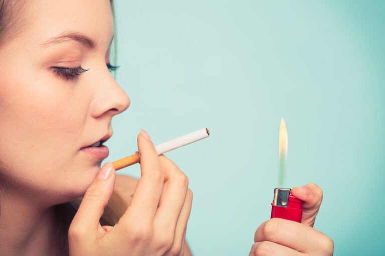 Girl using lighter to light cigarette. Association Santé Respiratoire France